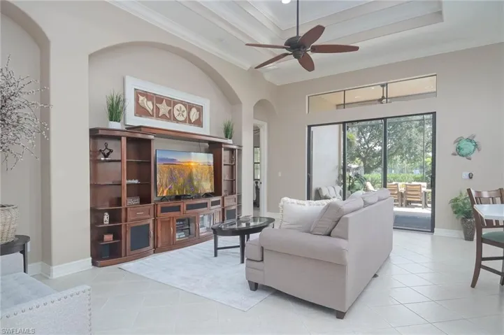 Tiled living room featuring ornamental molding and ceiling fan