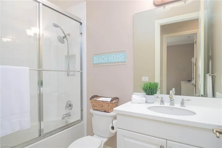 Full bathroom with bath / shower combo with glass door, vanity, and toilet
