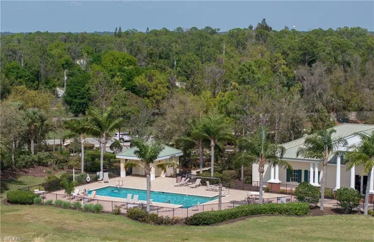 Outdoor swimming pool with surrounding paver deck, a shaded pavilion, and lounge seating