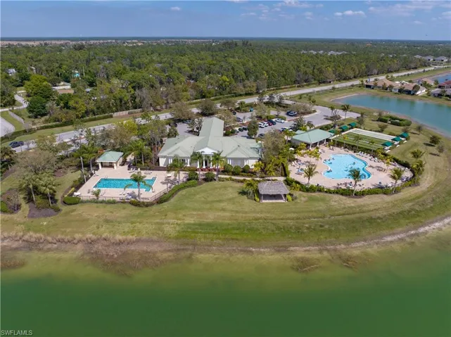 Resort-style amenities featuring two swimming pools, a central clubhouse building, covered outdoor seating areas, and expansive green spaces