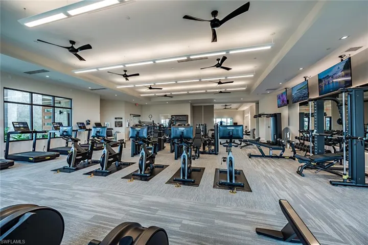 Gym featuring ceiling fan and light carpet