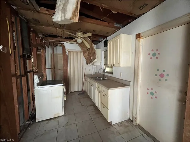 Kitchen featuring sink, tile flooring, ceiling fan, and washer / clothes dryer