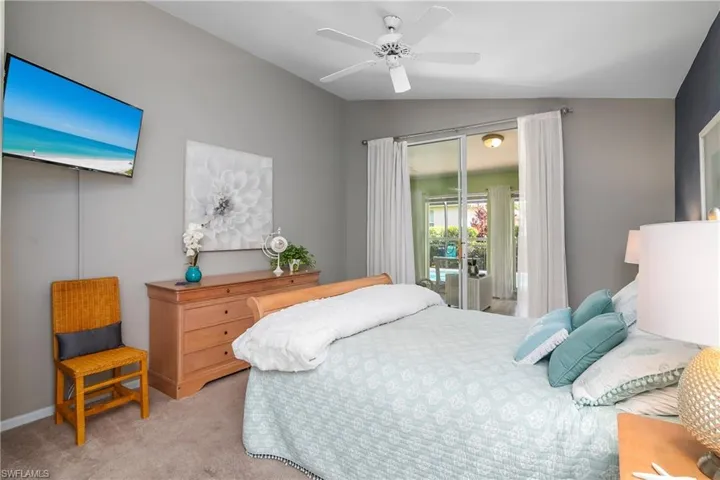 Carpeted bedroom with access to outside, lofted ceiling, and ceiling fan