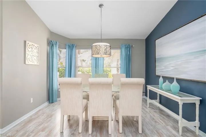 Dining room with light hardwood / wood-style floors and lofted ceiling