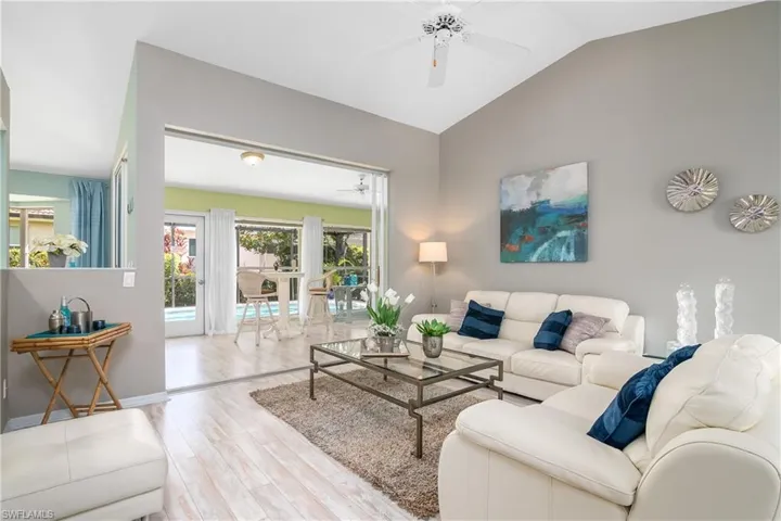 Living room featuring light hardwood / wood-style floors, ceiling fan, and vaulted ceiling