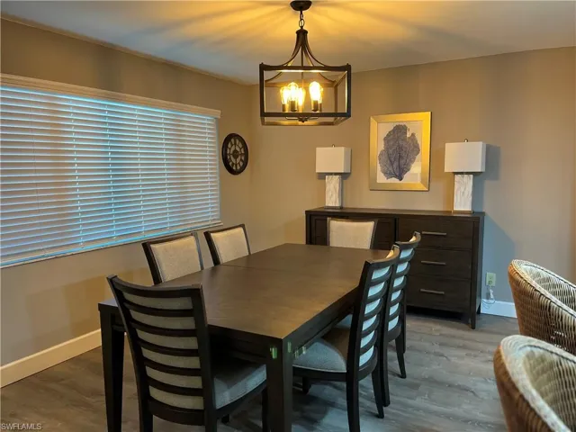 Dining space with wood-type flooring and a notable chandelier