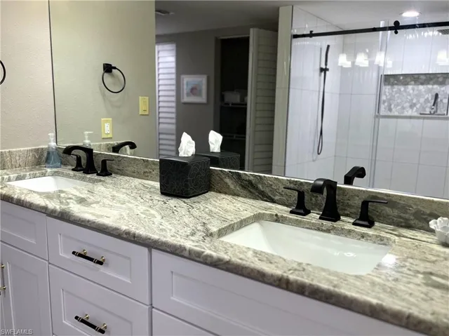 Bathroom featuring walk in shower and vanity