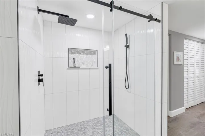 Bathroom with wood-type flooring and a shower with door