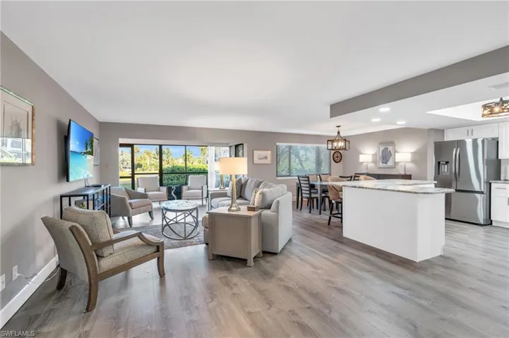 Living room with an inviting chandelier and light hardwood / wood-style flooring