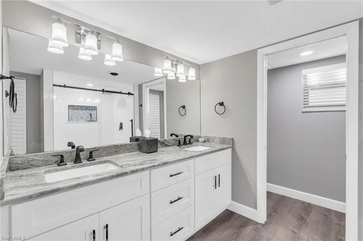 Bathroom featuring wood-type flooring, vanity, and an enclosed shower