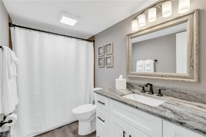 Bathroom featuring hardwood / wood-style floors, vanity, and toilet