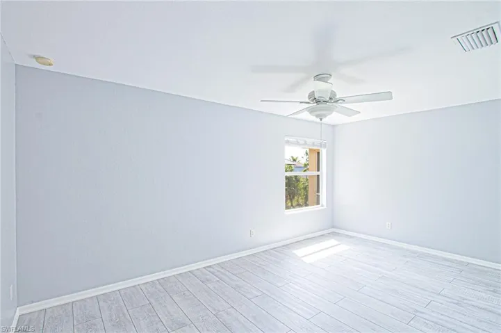 Empty room with light wood-style floors and a ceiling fan