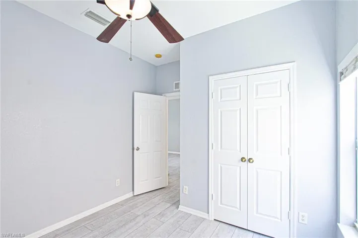 Unfurnished bedroom with light wood-type flooring, a ceiling fan, and a closet