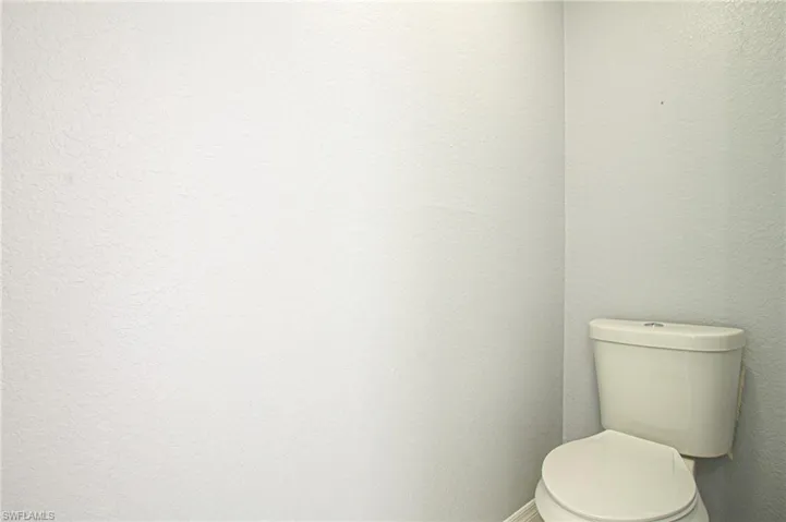 Bathroom with a textured wall and toilet