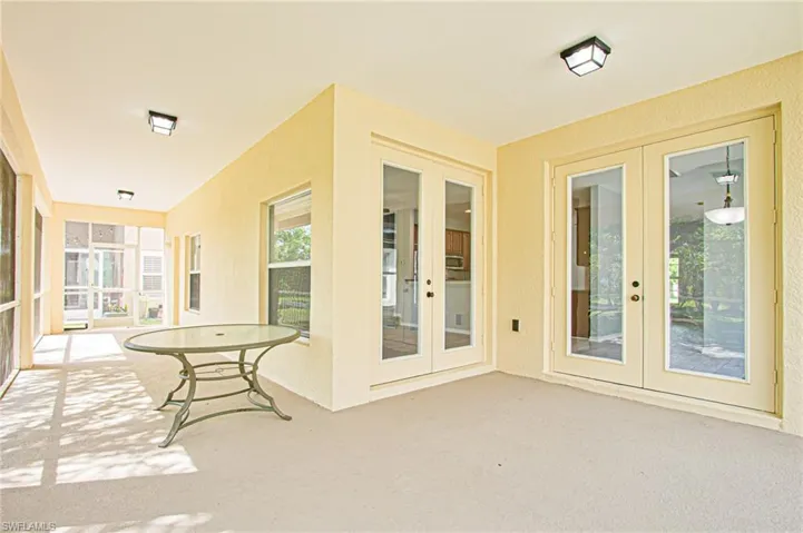 Unfurnished sunroom featuring french doors and carpet