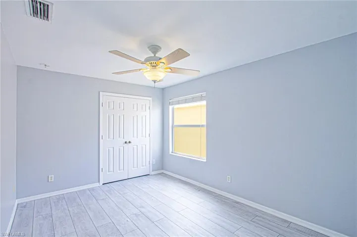 Unfurnished bedroom featuring ceiling fan, light wood-type flooring, and a closet