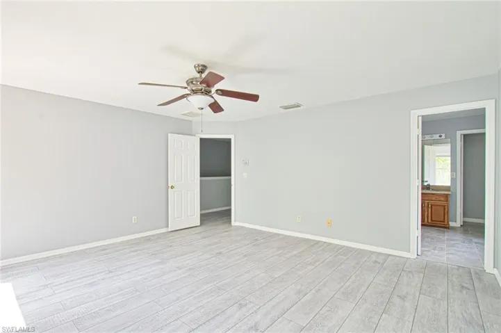 Empty room with light wood-style flooring and ceiling fan