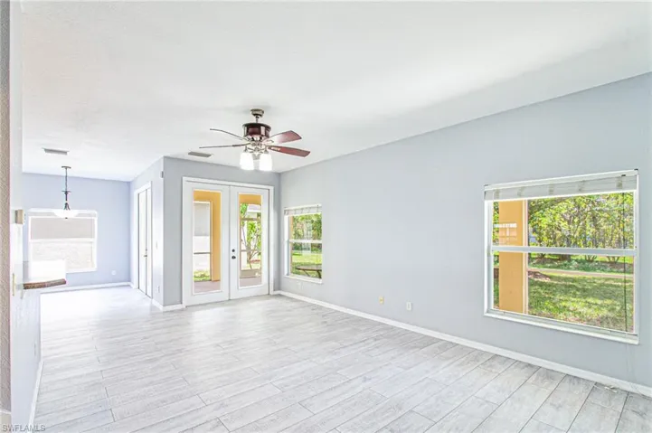 Unfurnished room with light wood-style flooring, a ceiling fan, and french doors