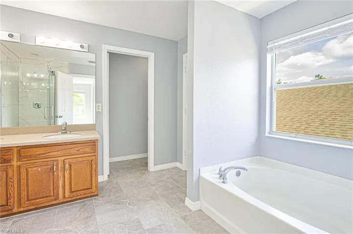 Bathroom with a stall shower, a bath, and vanity