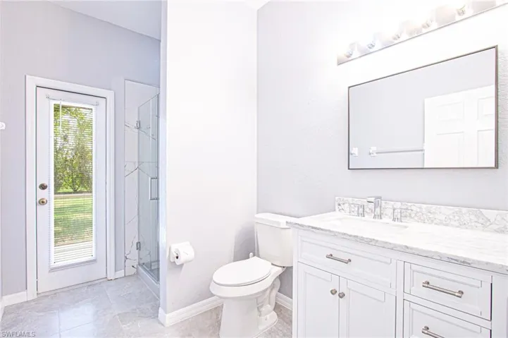 Full bath with vanity, a stall shower, and light tile patterned floors