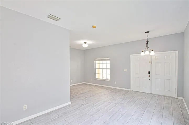 Entryway with baseboards and light wood-style flooring