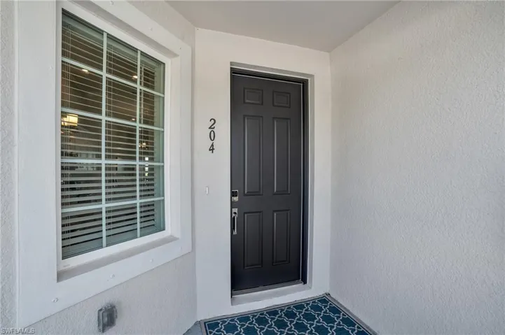 Doorway to property featuring stucco siding