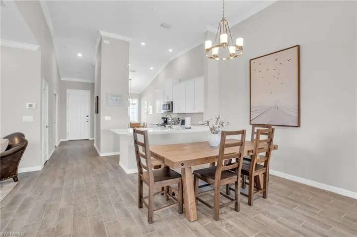 Dining space featuring recessed lighting, crown molding, baseboards, a chandelier, and wood tiled floor