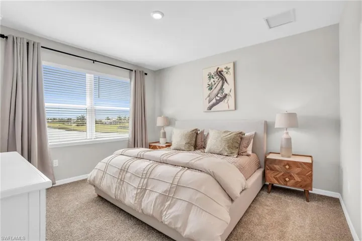 Bedroom featuring light carpet and baseboards