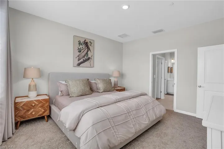Carpeted bedroom with visible vents and baseboards
