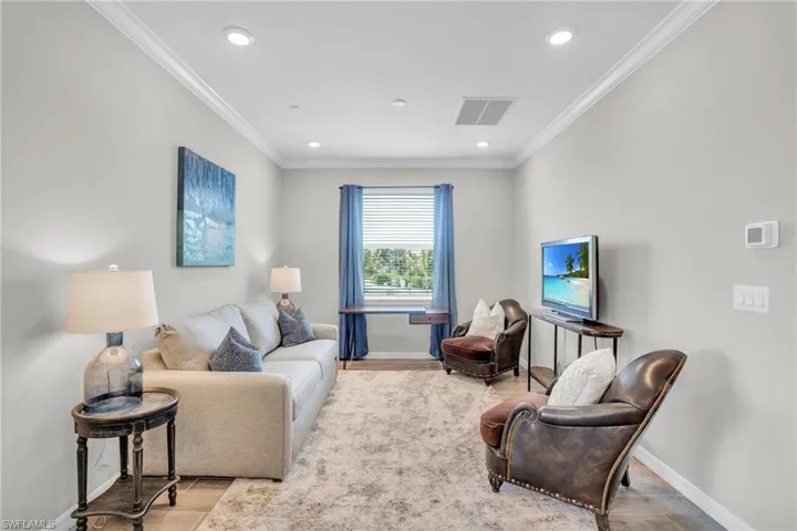 Living area featuring visible vents, baseboards, and ornamental molding