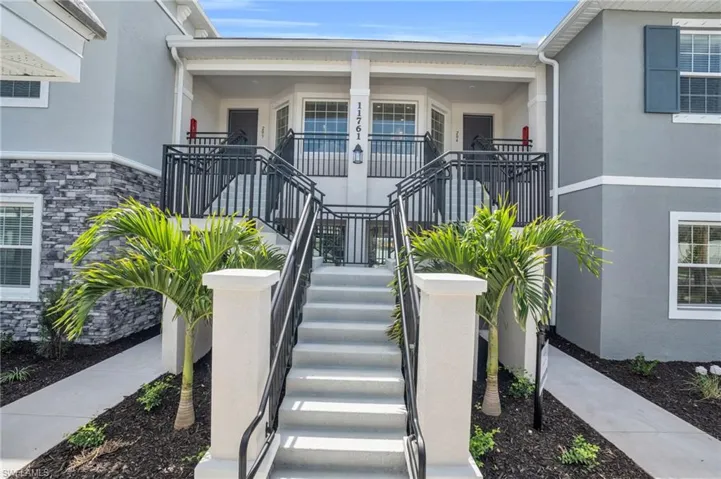 Property entrance with stucco siding, stone siding, and covered porch