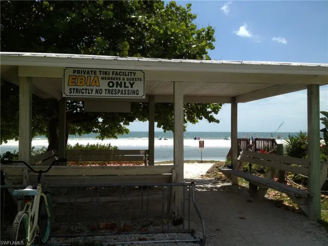 View of dock featuring a water view and a beach view