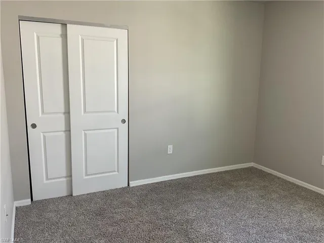 Unfurnished bedroom with baseboards, carpet floors, and a closet