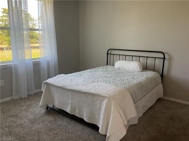Bedroom with baseboards and carpet