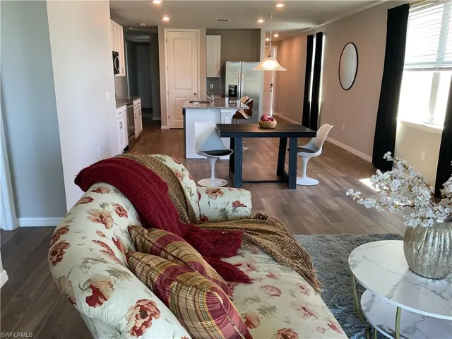 Living room with dark wood finished floors, recessed lighting, and baseboards