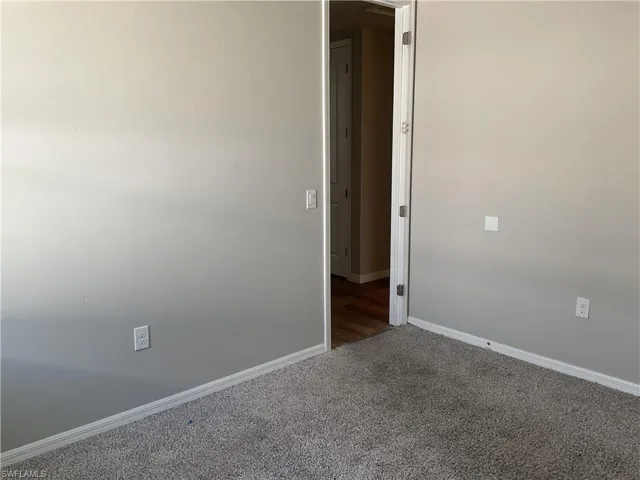 Carpeted empty room featuring baseboards