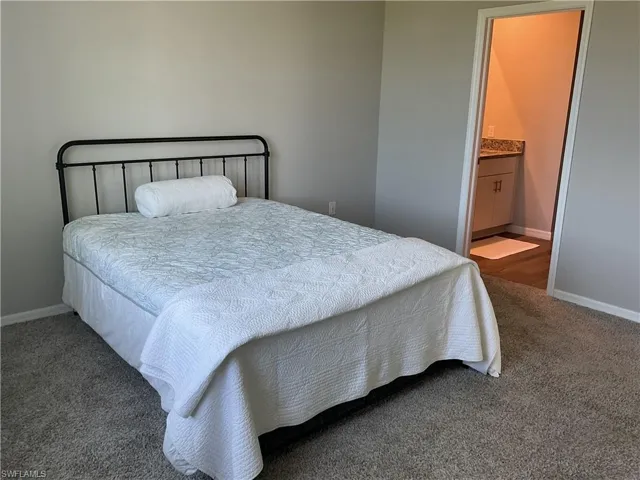 Carpeted bedroom featuring baseboards