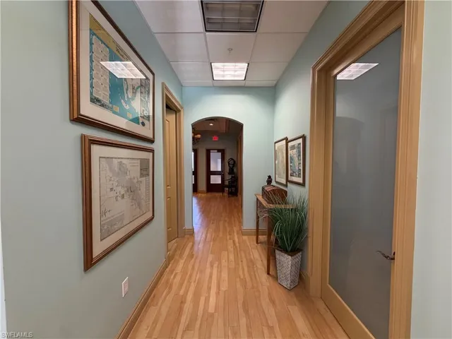 Hallway featuring wood-finish flooring and light-toned walls