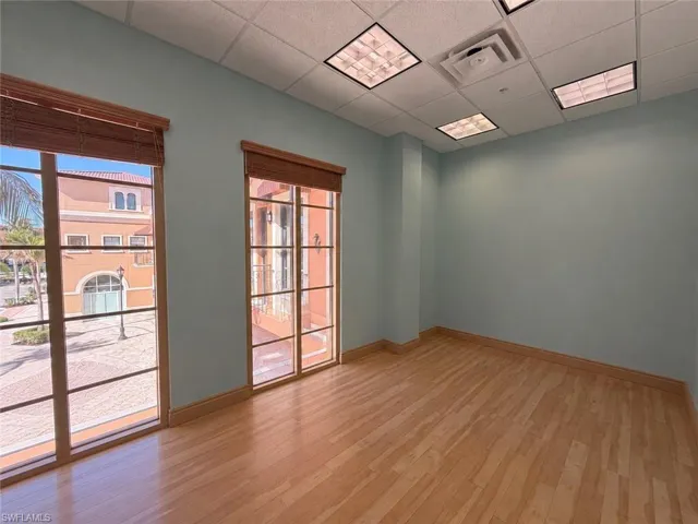Expansive room featuring wood-finish flooring and light blue walls
