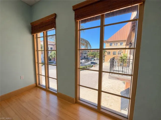 Two large grid windows with wood-finish frames and woven wood blinds