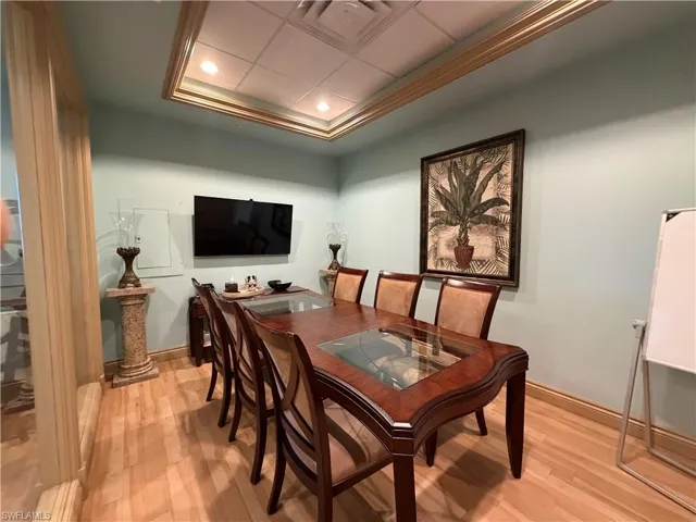 Light wood-finish flooring with a dropped ceiling featuring recessed lighting