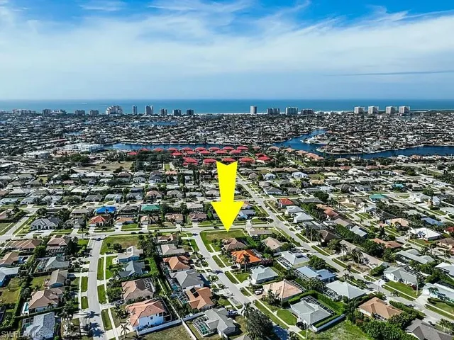 Aerial view of property and surrounding area with a nearby body of water and nearby urban area