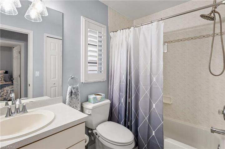 well-lit guest bath with nice tile work and linen closet