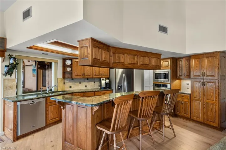 Kitchen featuring appliances with stainless steel finishes, sink, a high ceiling, and a kitchen island