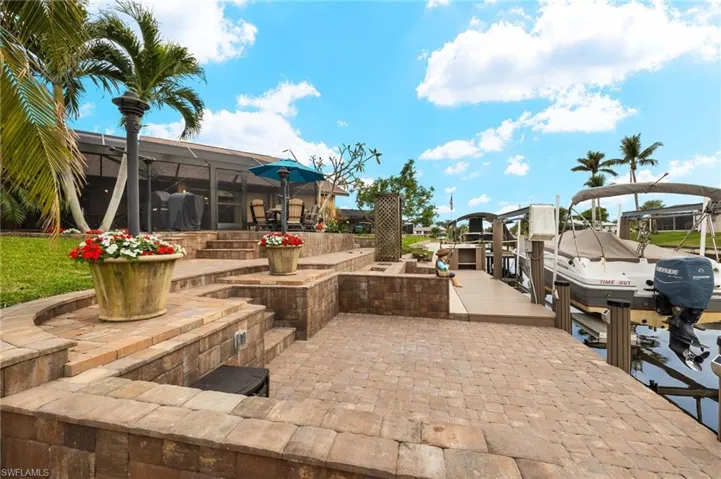 View of patio with a boat dock and a lanai