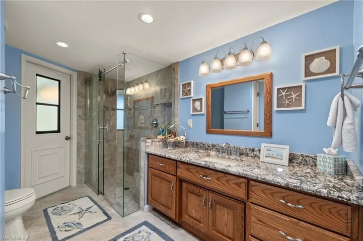 Bathroom with an enclosed shower, vanity, and toilet