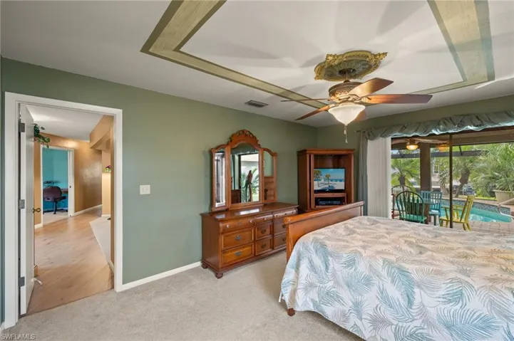 Bedroom featuring light carpet, ceiling fan, and access to outside