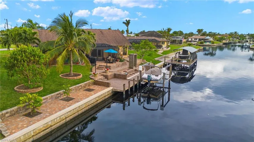Dock area with a water view, a lawn, and a lanai