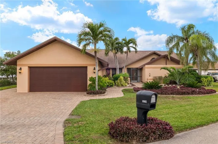 Single story home with a garage and a front lawn