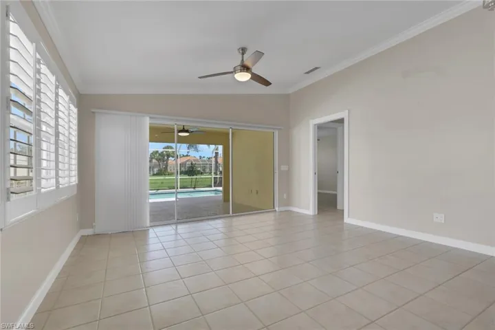 Tile flooring, crown molding, white plantation shutters, ceiling fan, and sliding glass doors